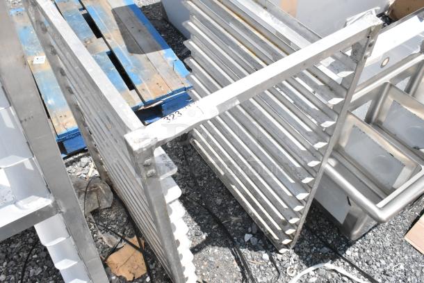 Metal baking rack with multiple shelves, showing signs of wear. Marked with number "323" indicating auction lot.