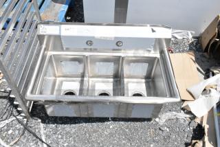 Triple-compartment stainless steel sink, new, with protective film. Includes pre-drilled faucet openings and drainage holes.