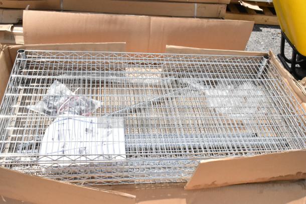 Metal wire shelving unit in open box with assembly instructions and hardware, new condition.