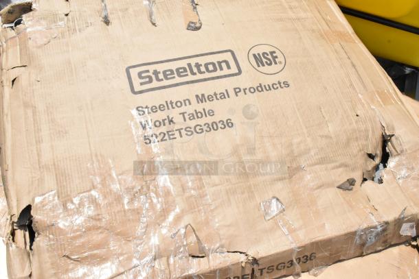 Damaged cardboard packaging for Steelton Metal Products Work Table, model 522ETSG3036, marked NSF certified.