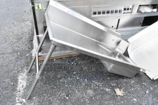 Stainless steel commercial chute with angled design and sturdy legs. Visible labels indicate model 319. Excellent condition.