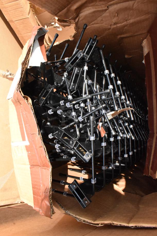 Box of metal clamps with black handles, partially opened. Clamps appear new, suitable for woodworking or construction tasks.