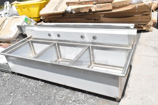 Stainless steel three-bay commercial sink in used condition, with mounting holes and a sturdy base.