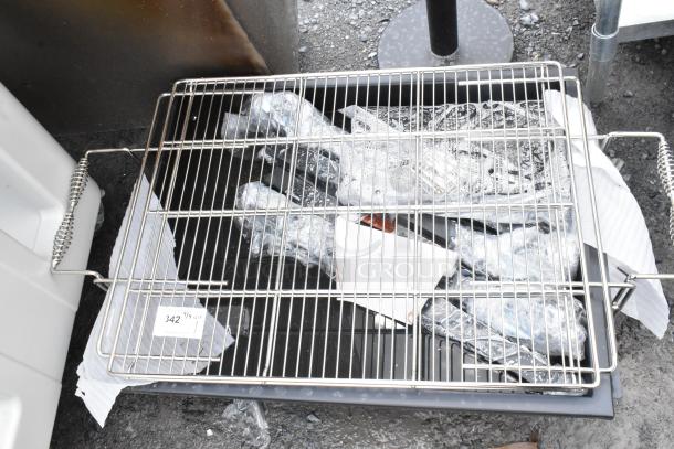 Stainless steel grill top with handles, resting on packaged items. Tag reads "342 QTY 1." Excellent condition.