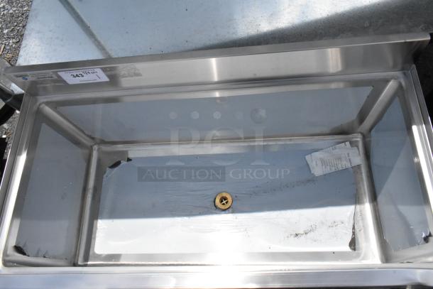 Stainless steel sink with central drain, label marked "343," good condition, minor residue visible, no additional markings.