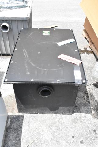 Black industrial sump tank with pipe outlet, scratches on top. Attached label marked "Important Notice." Good condition.