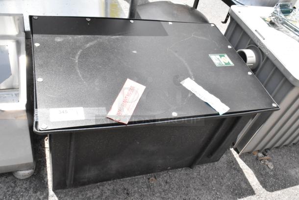 Black industrial storage box with visible scuffs. Includes important notice labels and a tag marked "345."