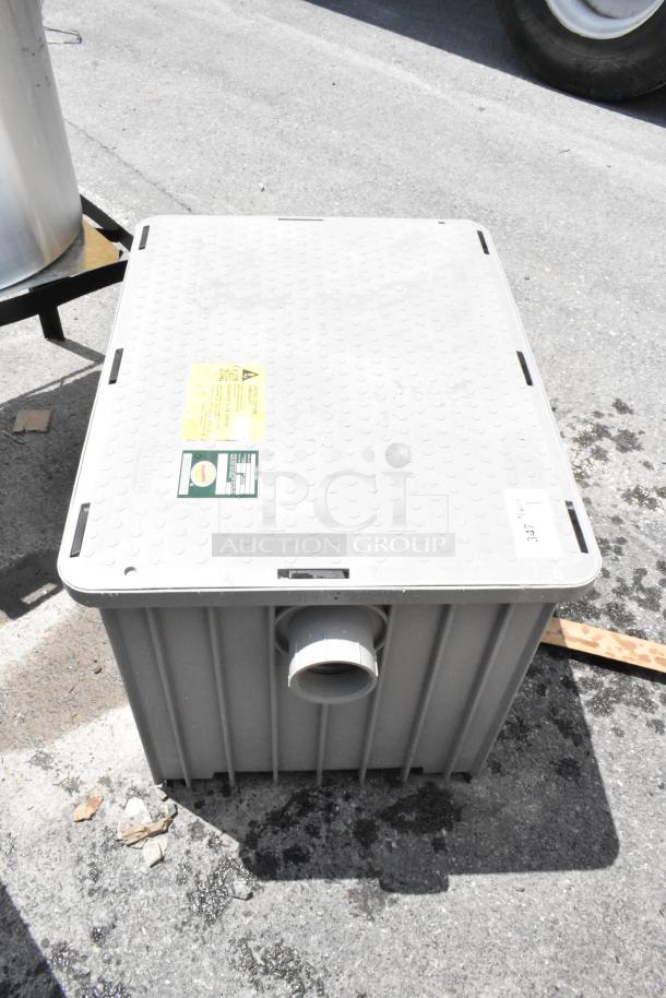 Large gray plastic container with lid, featuring a central pipe outlet. Labels on lid include safety warnings and model info. Used condition.