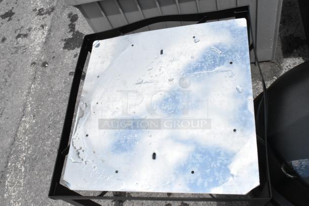 Metal tabletop with holes and watermarks on a black frame, minor wear visible. Perfect for industrial-style decor.