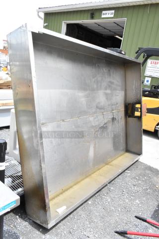 Large industrial stainless steel exhaust hood, showing visible wear and rust stains. Ideal for commercial kitchen ventilation.