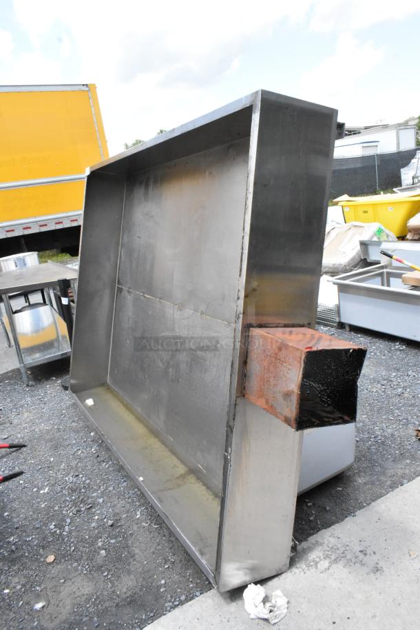 Large stainless steel industrial vent hood, showing signs of rust and wear, suitable for commercial kitchen use.