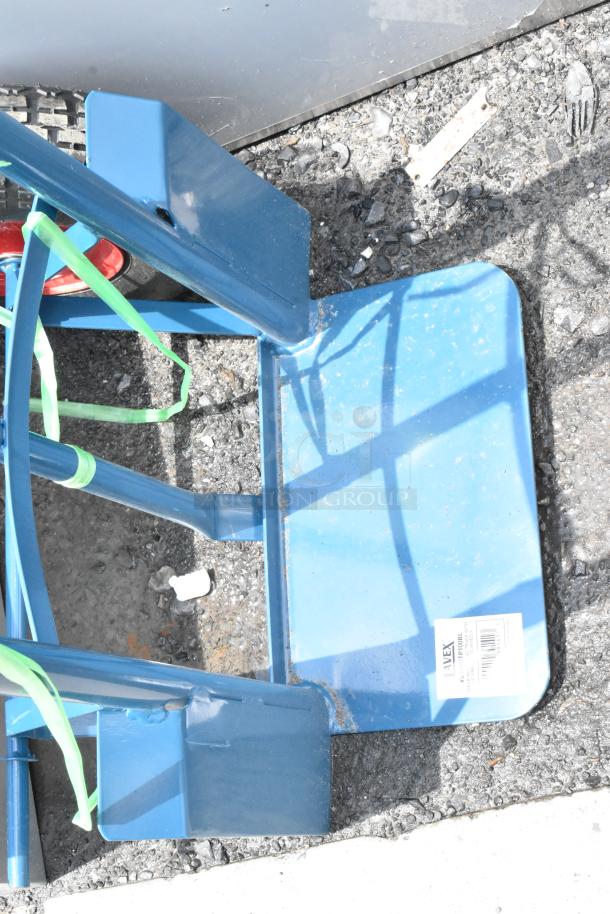Blue metal hand truck with red wheels, showing minor scratches. Label reads "WEX" with product details. Good condition.