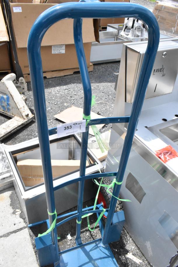 Blue metal hand truck with label "353" attached. Condition appears good, equipped with two wheels, secured with green ties.