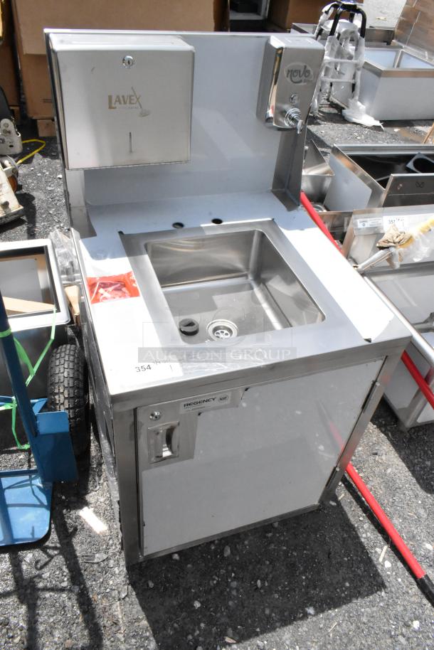 Stainless steel commercial hand sink with "Lavex" and "Novo" dispensers, labeled "Regency NSF," showing minor wear.
