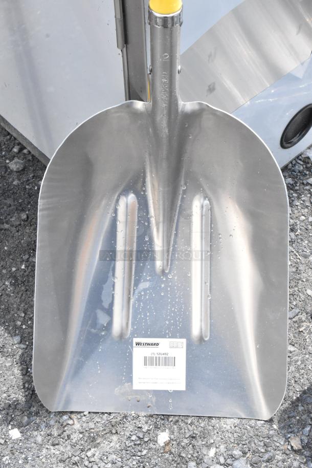 Westward snow shovel with bright metal blade and yellow handle. New condition, item number 12U492 visible on label.