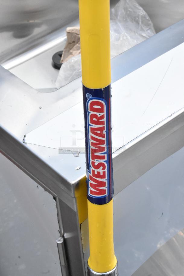 Westward tool handle, yellow with blue and red branding label, near stainless steel surface; condition appears new.