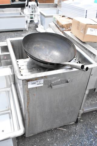 Large steel wok with twin handles resting on a stainless steel industrial sink. Visible tag reads "358" and "w/ contents." Slight rust visible.