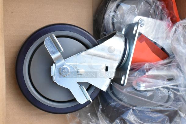 Heavy-duty swivel caster wheel with brake, metal plate, and blue rim. New condition, partially wrapped in plastic.