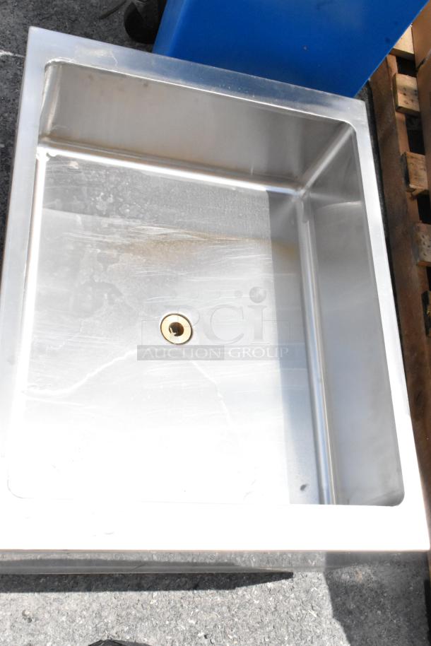 Stainless steel sink, square shape, used condition, visible surface wear, central drain hole, no visible brand.