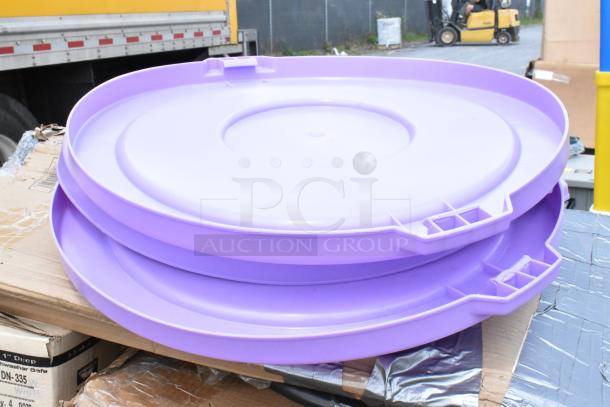 Two light purple plastic drum lids on a wooden pallet, showing stacking design and snap closures, in good condition.