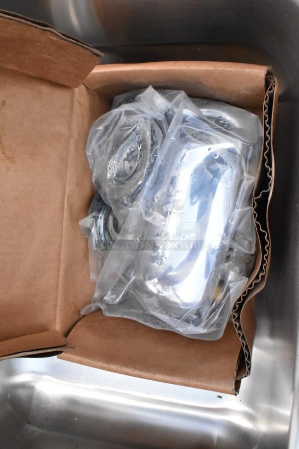 Packaged stainless steel automotive engine parts in a cardboard box, sealed in clear plastic with moisture inside. Suitable for restoration projects.