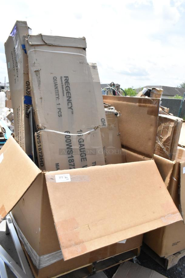 Large, assorted cardboard boxes including a Regency Space Solutions packaging, showing signs of wear and outdoor exposure.
