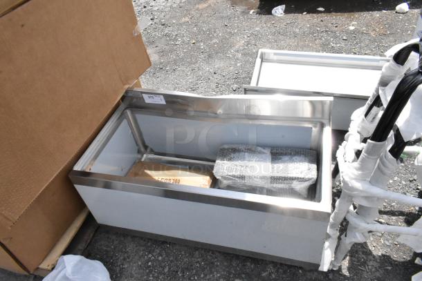Stainless steel sink basin, new condition, wrapped accessories. Auction tag number 375 attached.