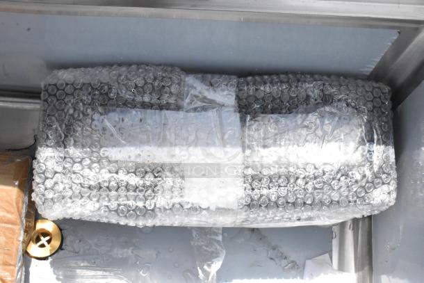 Item wrapped in bubble wrap, with a visible cardboard corner. Condition and type unknown. Appears packaged for protection.