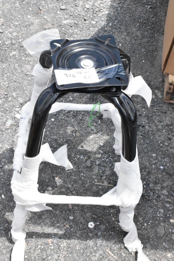 Black metal seat base with swivel mechanism, wrapped for protection. Visible label with "376, 94 011, x2". New condition.