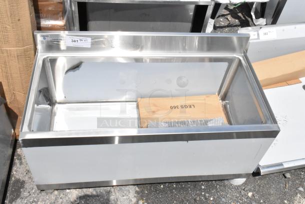 Stainless steel commercial ice bin with backsplash, new condition, includes wooden packaging marked "LEGS 360". Auction label "381".