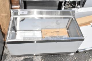 Stainless steel commercial ice bin with backsplash, new condition, includes wooden packaging marked "LEGS 360". Auction label "381".