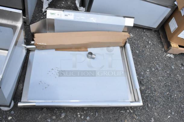 Stainless steel tray with a cardboard package and metal fitting, showing minor wear. Tag indicates "382" quantity label.