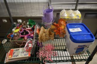 Assorted kitchen items including cookie cutters, squeeze dispensers, floral decorations, and a plastic container.