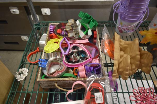 Box of assorted colorful cookie cutters in various shapes, good condition, includes hearts and holiday-themed designs.