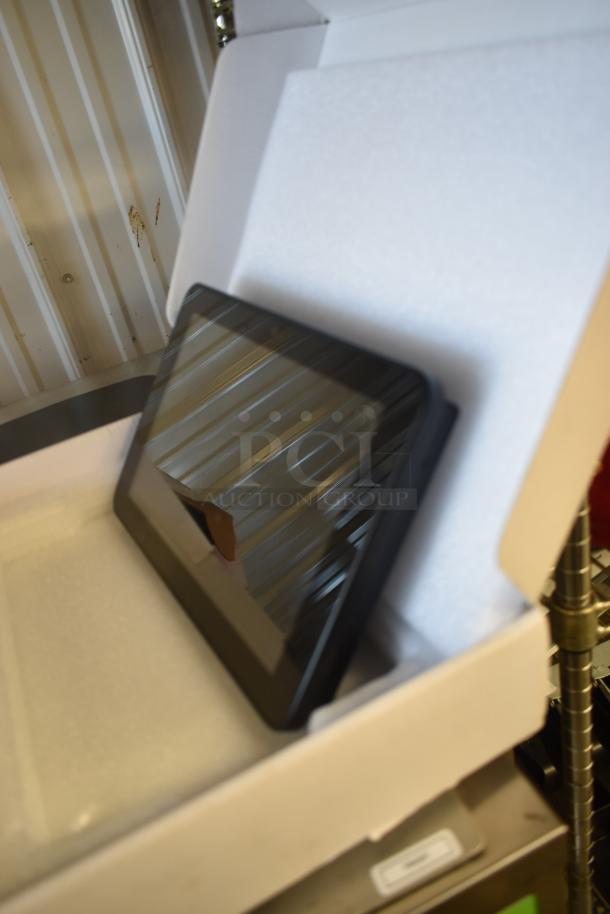 Tablet in open box, reflective screen, appears in new condition. No visible markings or labels. Suitable for auction.