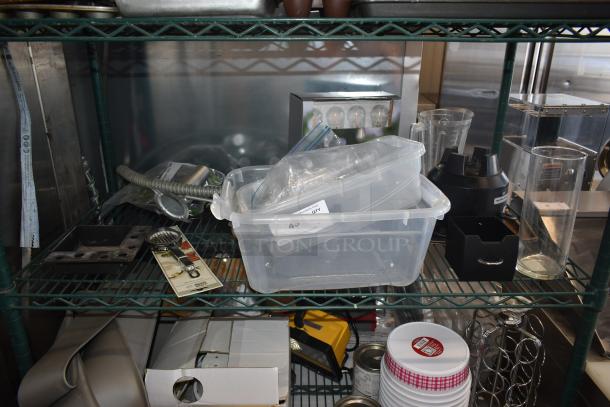 A wire shelf with assorted kitchen items includes a plastic container, blender base, glass jars, and spiral whisk. Some items packaged, labeled "Qty".
