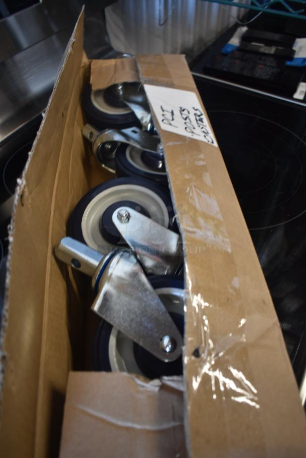 Box of heavy-duty caster wheels with metal mounts. New condition. Label reads "Part #9235 Casters."