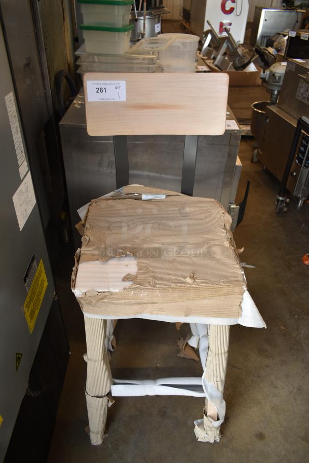 Wooden chair with a natural finish, partially wrapped in protective cardboard. Auction tag reads "261, QTY 1."