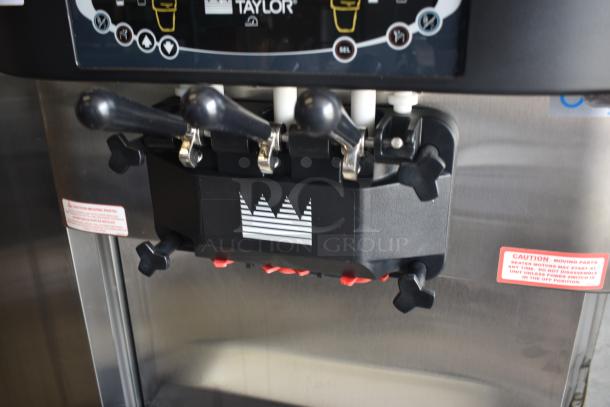 Taylor ice cream machine with three levers, digital display, crown logo, and caution labels. Appears in good condition.