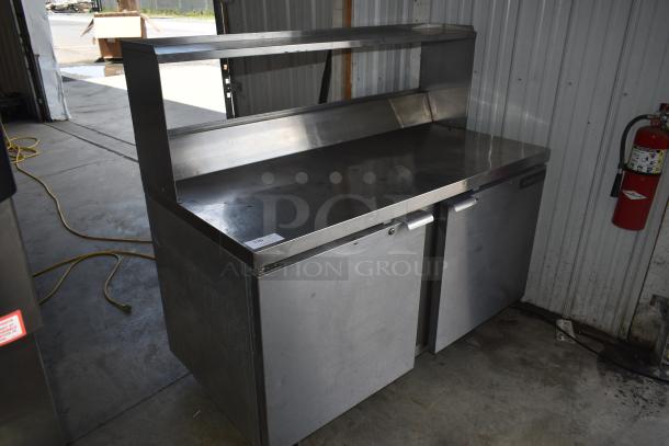 Stainless steel commercial prep table with two under-counter storage doors, mounted tag reads "116," in good condition.
