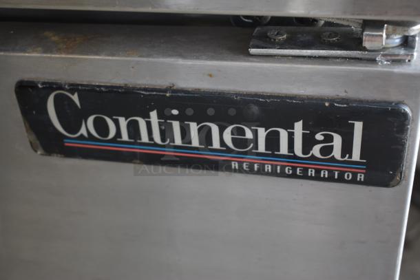 Continental refrigerator door with visible wear, featuring the brand label. Hinge detail and stainless steel surface shown.