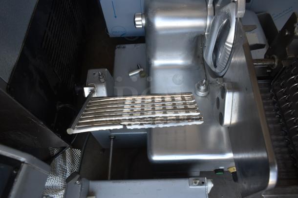 Industrial metal slicer with multiple blades, stainless steel finish, in good condition. No labels or markings visible.