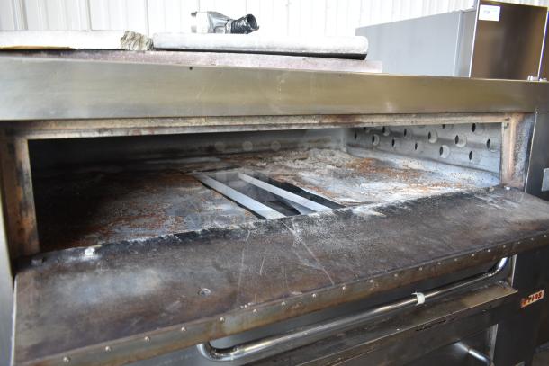 Commercial pizza oven, metal construction, showing interior wear. Includes heating elements and visible markings of use.