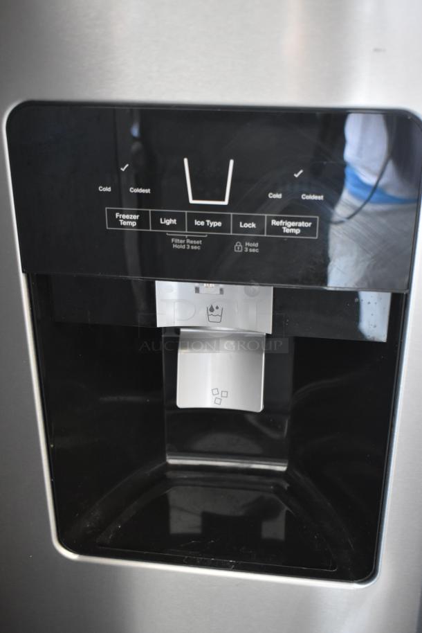 Stainless steel refrigerator water and ice dispenser with temperature controls, light, and lock features.