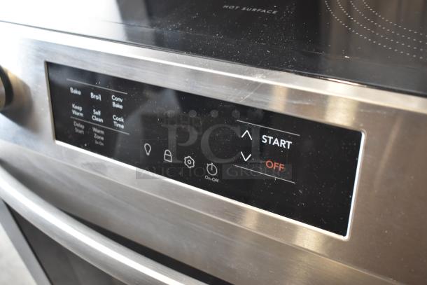 Close-up of stainless steel oven control panel with bake, broil, and self-clean functions. Light wear visible.