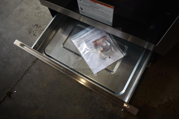 Open Frigidaire drawer with installation kit in plastic bag, includes anti-tip bracket and instructions. Item appears new.
