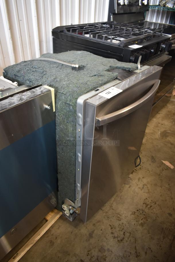 Stainless steel dishwasher, modern design, minor wear. Auction tag "122". Insulation padding visible.