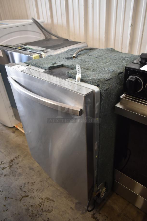 Stainless steel built-in dishwasher, front control panel with markings, unpacked, showing hose connection. Good condition.