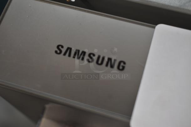 Samsung device with visible logo, silver metallic finish, standard condition, possible electronics or appliance component.