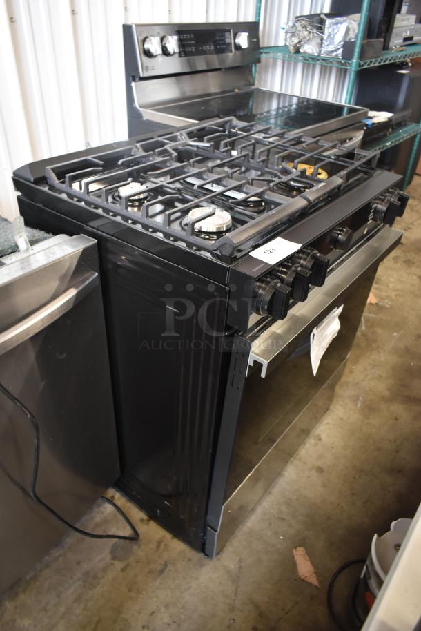 Black LG gas range with five burners, digital controls, and stainless steel finish. Model number tag visible, excellent condition.